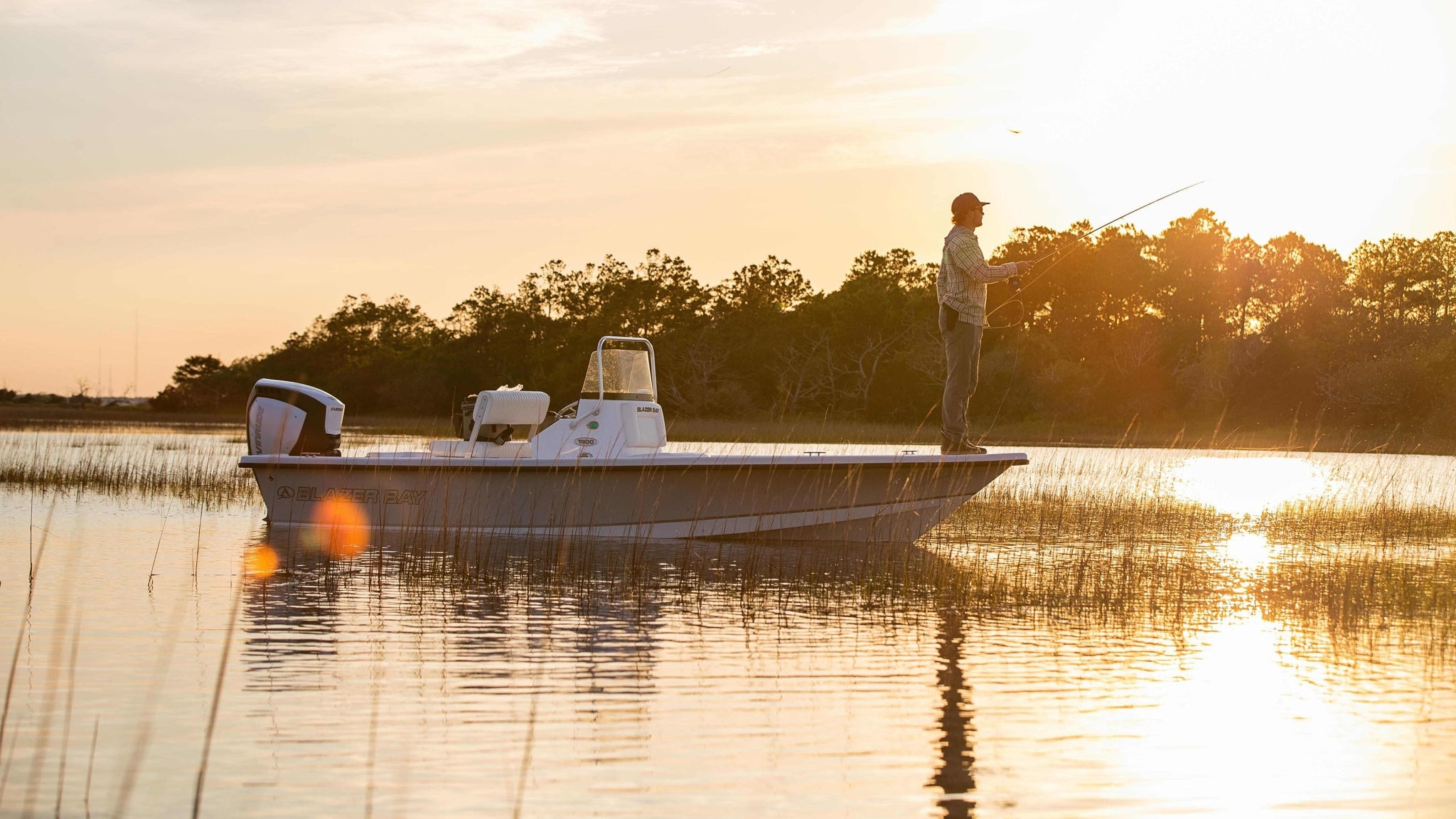 Evinrude engine attached to fishing boat while a man is fishing